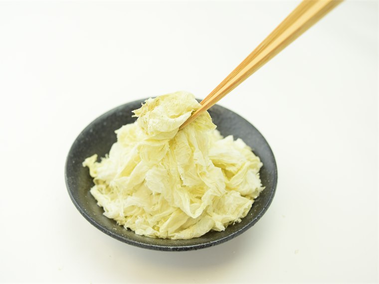 箸で持ち上げた純白で透き通るほど薄い上白おぼろ昆布